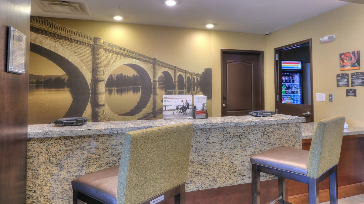 A welcoming interior space with a granite counter, vivid bridge mural, and comfortable seating area. The area feels like a friendly reception or shared service space, suggesting a high standard of guest care and an inviting atmosphere.